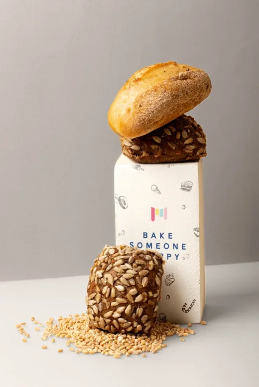 a bagel sitting on top of a box of some kind of bread.