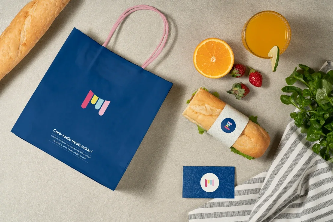 a blue shopping bag next to some fruit and bread.