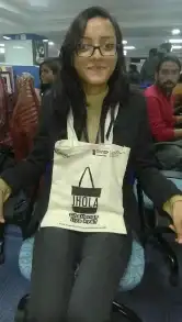 a woman sitting in a chair holding a bag.