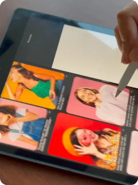 a person holding a apple pencil and selecting a picture on a ipad.