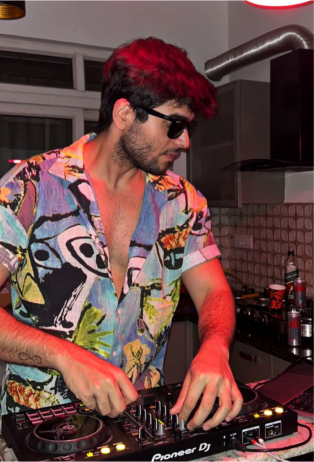 a man in a colorful shirt djing at a party.